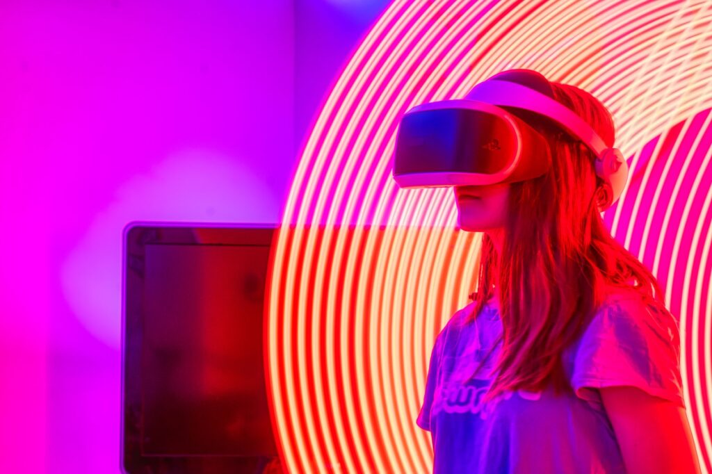 A woman wearing VR glasses immersed in a neon-lit environment with swirling lights.